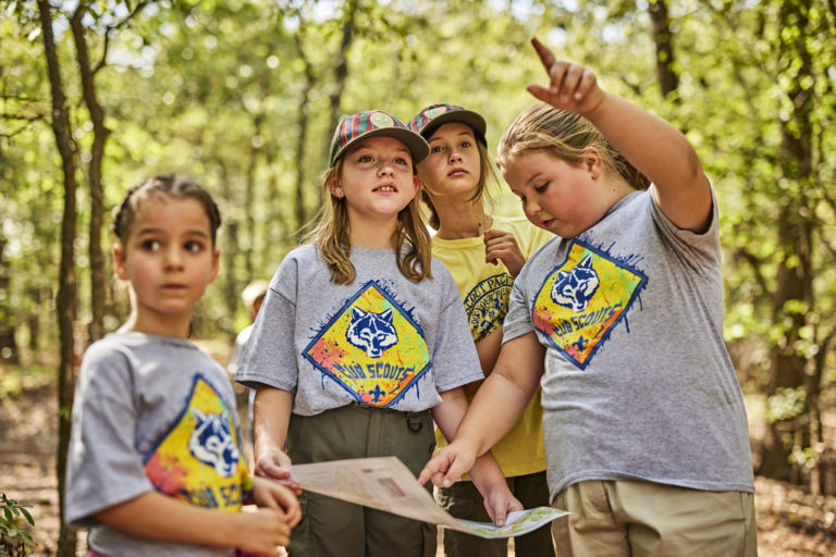 Cub Scouts at the lake - girls looking at a map and pointing
