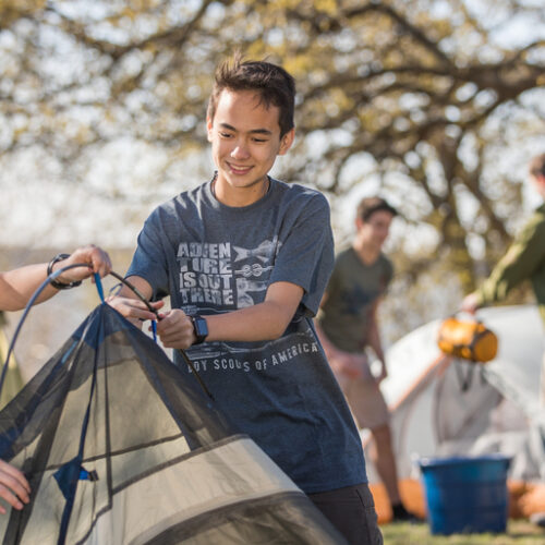 Two Scouts work together to set up a tent