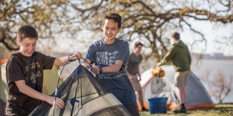Two Scouts work together to set up a tent